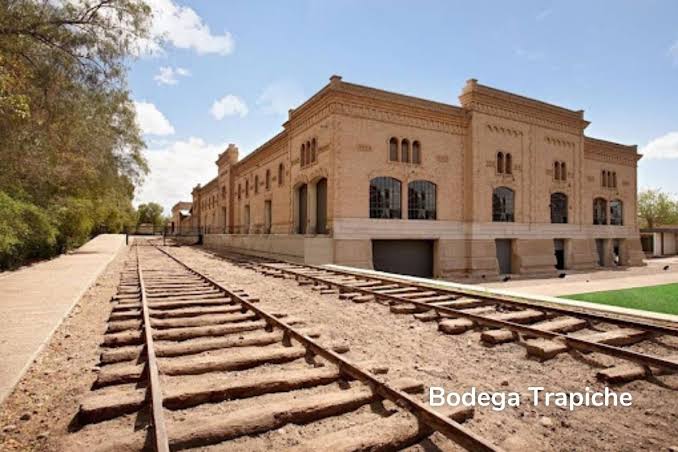 Edificio histórico de ladrillo de la bodega Trapiche junto a las vías del tren